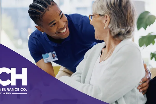 Healthcare professional caring for elderly patient with PCH Mutual Insurance Co. branding